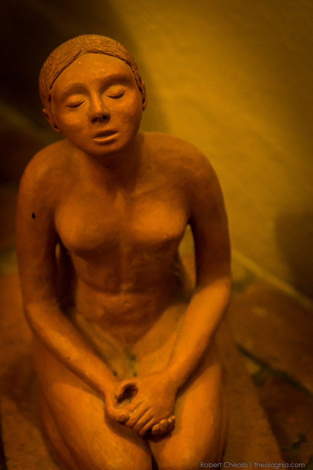 Clay statue of a woman in prayer and meditation