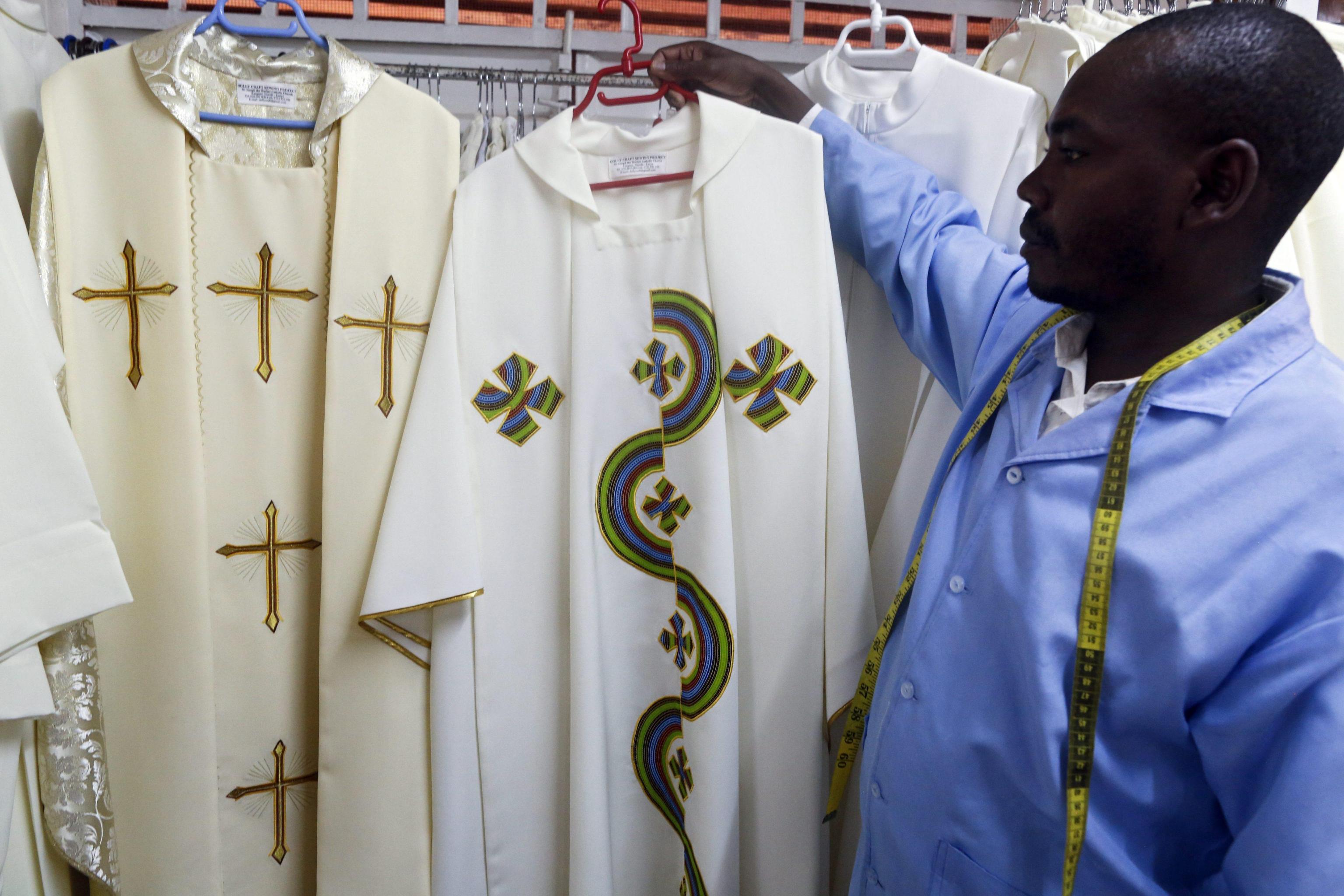 A tailor at St. Joseph the Worker Catholic Church shows vestments to be worn by Pope Francis during his visit to the country in Nairobi's Kangemi neighborhood