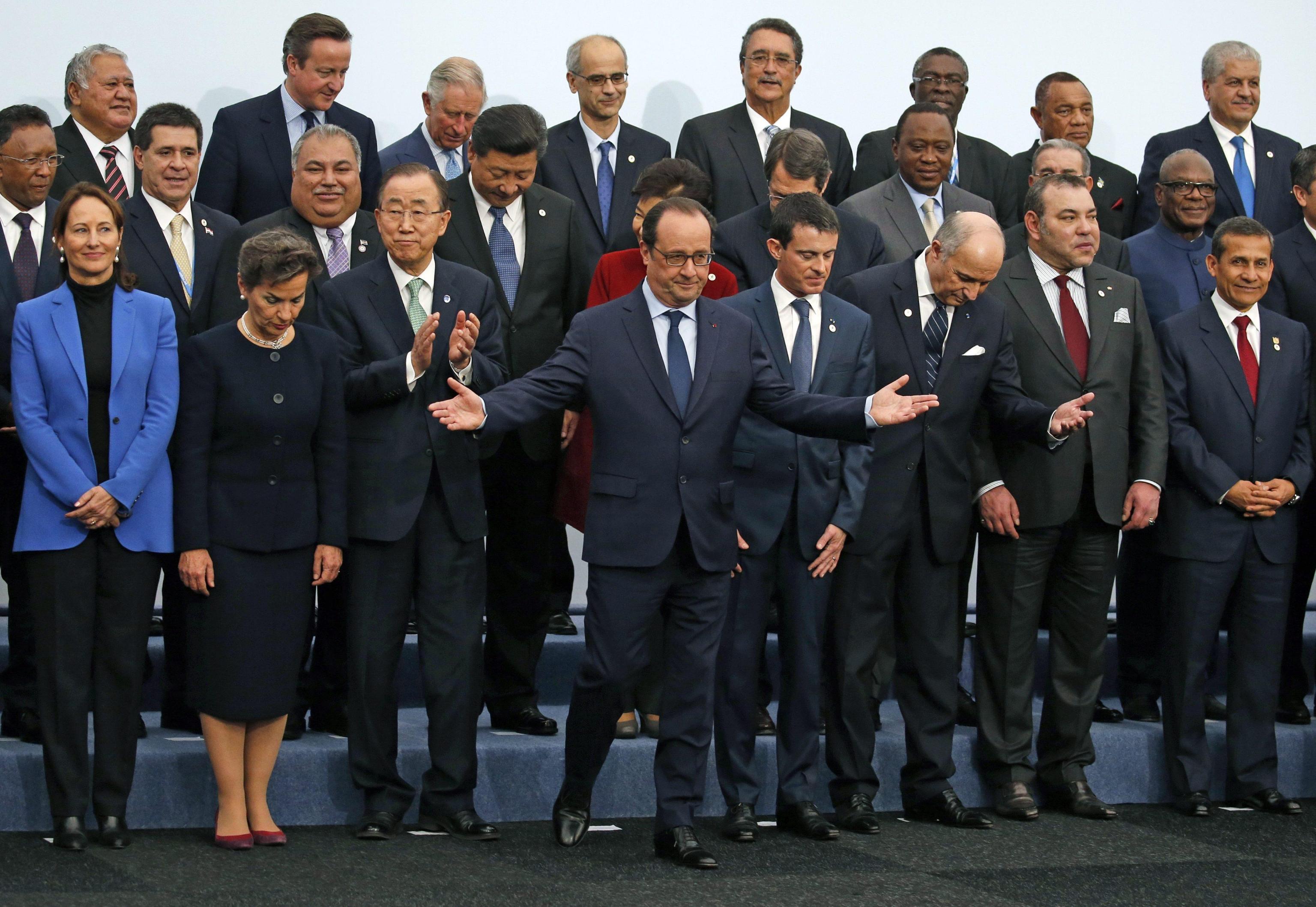 French President Francois Hollande gestures when posing with world leaders for a family photo at the COP21